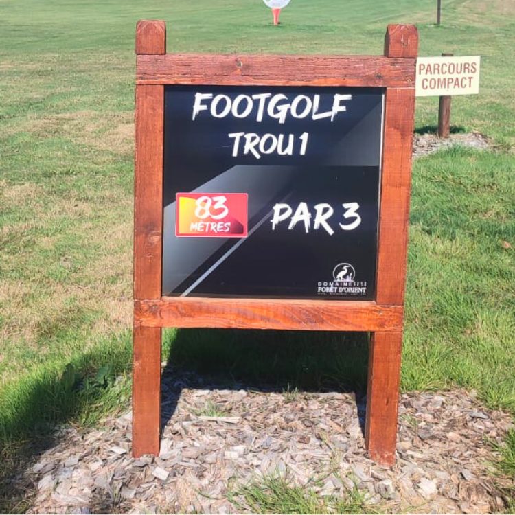 Panneau du trou 1 footgolf, 83 mètres, par 3, Domaine de la Forêt d'Orient, parcours compact à l'arrière.